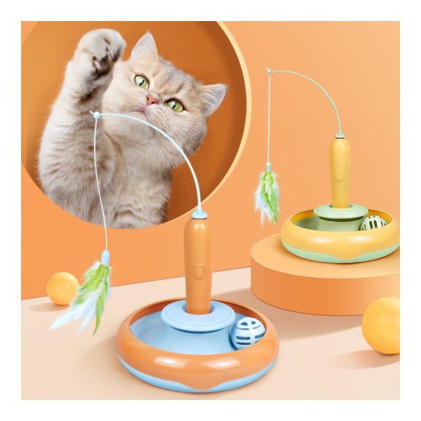 Cat playing with a feather turntable toy indoors